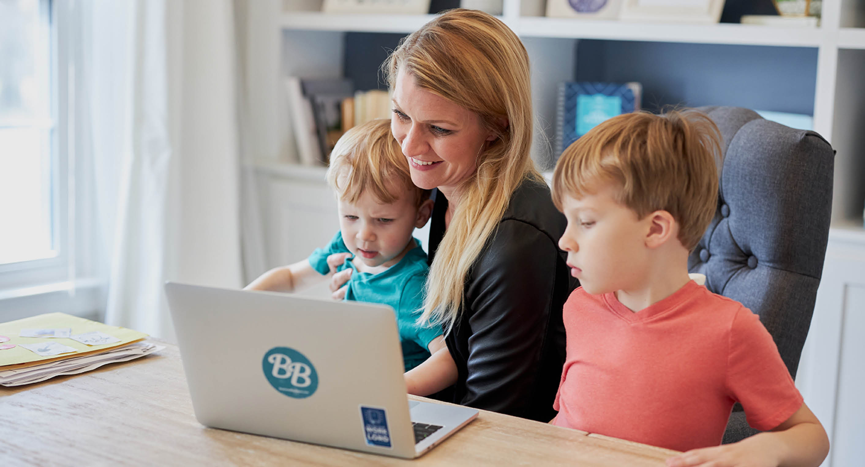 Mother working from home with two children aside 