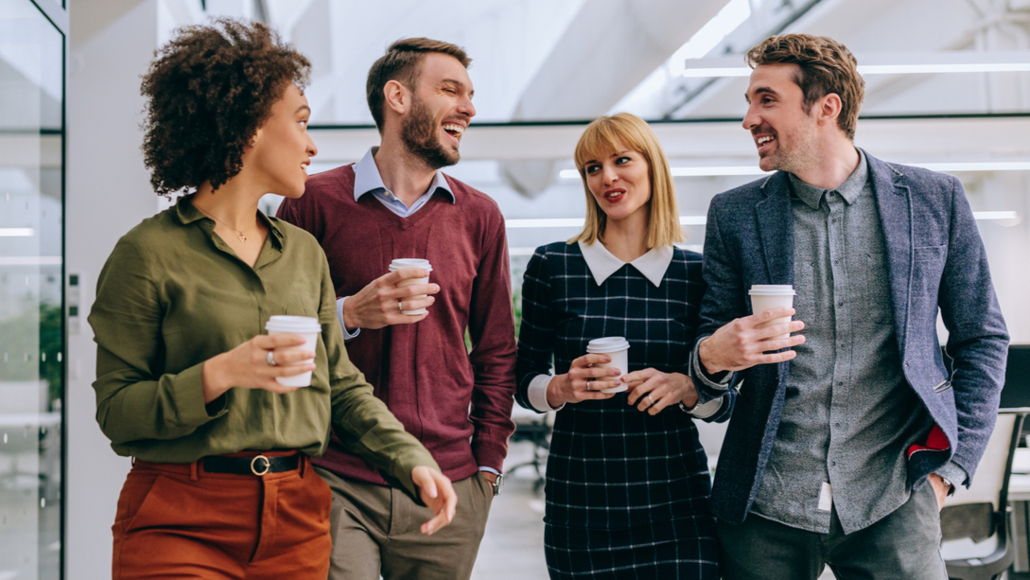 Colleagues holding coffee in an office space