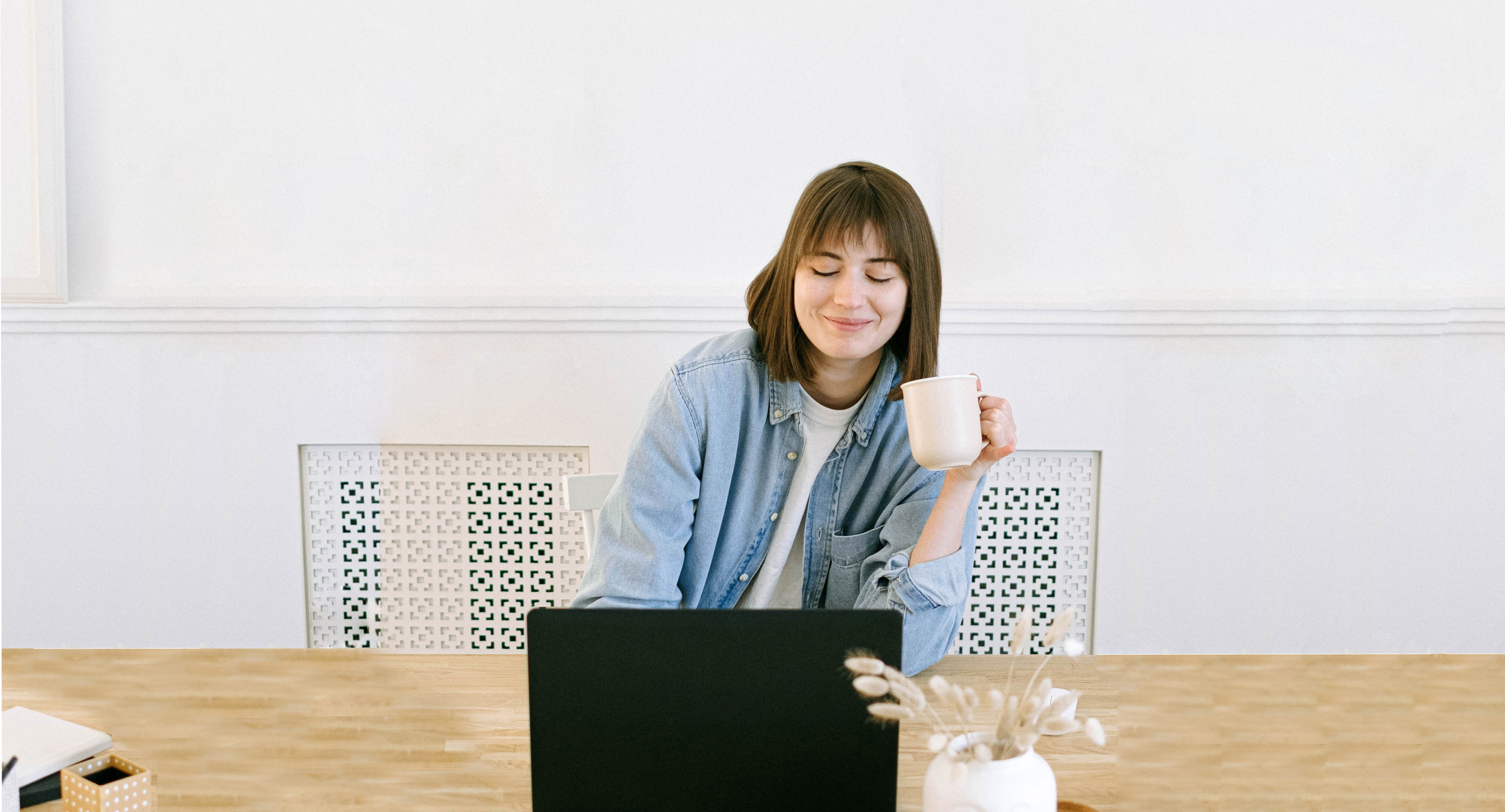 Female drinking coffee working on her laptop